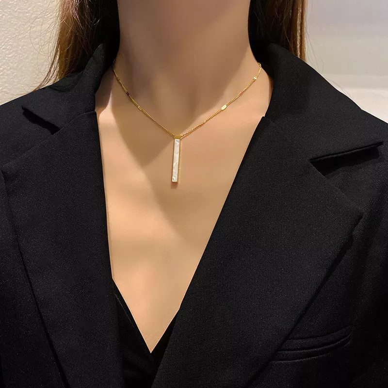 Elegante edelsteen ketting van staal en schelpje in een gouden frame hanger